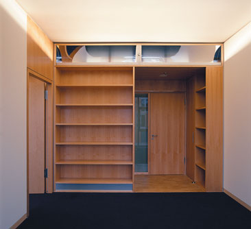 Bürorückseite mit Bücherregalen und integrierter Beleuchtung